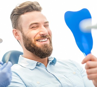 Smiling State College patient showing new dental implants